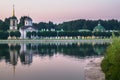 Church with bell tower next to the pond and park pavilion `Grotto` in museum-estate Kuskovo, Moscow. Royalty Free Stock Photo