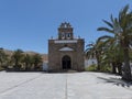 Church with bell tower and palm trees.