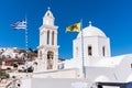 Church and bell tower in typical Greek style in Santorini with flag of Greece and yellow Double-headed eagle Royalty Free Stock Photo