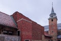 Church and belltower in akershus fort in Oslo on a cold winter day. Visible houses and big belltower made of red brick. Royalty Free Stock Photo