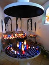 Lighted candles and statues in chapel