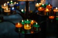 Church candles in red, green, blue and yellow transparent chandeliers Royalty Free Stock Photo