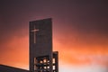 Red sunset on the sky above a modern church with christian cross Royalty Free Stock Photo