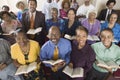 Church congregation sitting on church pews with Bible portrait high angle view