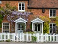 Church Cottages on The Ridgeway in Mill Hill, northwest London UK. Characterful cottages are covered in purple flowered wisteria.