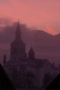 Church covered in mist with sunlit cloud