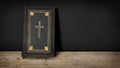 Church faith Christian background - Old holy bible with golden cross on old rustic vintage wooden table and black wall Royalty Free Stock Photo