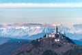 Church on hill with the alps in the background