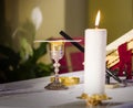 Lit candle illuminates chalice with wine and ciborium with the host, ready for the communion of the faithful Royalty Free Stock Photo