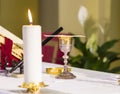 Lit candle illuminates chalice with wine and ciborium with the host, ready for the communion of the faithful Royalty Free Stock Photo