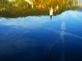 The Church of Mary the Queen mirrored in the water of Lake Bled in autumn.