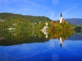 The Church of Mary the Queen mirrored in the water of Lake Bled in autumn.