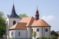 Church named Nanebevzeti panny Marie in Vraclav village, sacral historic heritage with tower nad red roof on the hill, blue sky