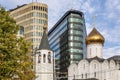 Church next to modern houses against the blue sky on a sunny day. Contrast of architecture Royalty Free Stock Photo