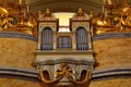 church organ musical instrument closeup. vertical tin pipes of various sizes. rich gilded decorative leaf shaped ornaments Royalty Free Stock Photo