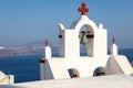 Church with red cross on the island of Thirasia overlooking Oia and Thira in Santorini, Greece. Royalty Free Stock Photo