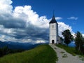 Church of Saints Primus and Felician at Jamnik in Gorenjska, Slovenia with dark storm clouds above Royalty Free Stock Photo