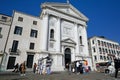 Facade of a Catholic church with tourists and hawkers in front