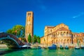 Church of Santa Maria e San Donato and bell tower brick building, bridge across water canal with motor boats in Murano islands