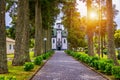 Church of Sao Nicolau (Saint Nicolas) with an alley of tall trees and hydrangea flowers in Sete cidades on Sao Miguel island, Royalty Free Stock Photo