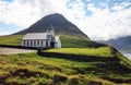 Church by the sea with ocean and mountain panorama, Vidareidi, Faroe Islands, Denmark, Northern Europe Royalty Free Stock Photo