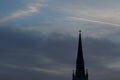 Church spire with cross high up in the sky silhouette in the morning