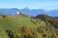 The church of St. Primoz in Slovenia near Jamnik with colorful autumn trees and blue sky Royalty Free Stock Photo