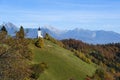 The church of St. Primoz in Slovenia near Jamnik with colorful autumn trees and blue sky, Slovenia Royalty Free Stock Photo