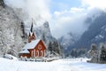 A church stands amidst a snowy mountain, showcasing the stunning landscape in its serene surroundings, A small country church Royalty Free Stock Photo