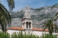 Church steeple against Biokovo mountain in town Makarska, Dalmatia, Croatia Royalty Free Stock Photo