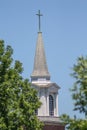 Church Steeple against blue sky with green trees. Royalty Free Stock Photo