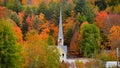 Church steeple between autumn trees