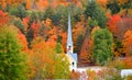 Church steeple between autumn trees