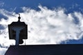 Church steeple and bell tower silhouette against silver cloud