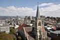 church, with steeple and bell tower, surrounded by bustling cityscape