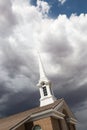 Church Steeple Tower Below Ominous Stormy Thunderstorm Clouds. Royalty Free Stock Photo