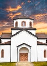 Church at sunset with prominent bell tower and arched entrances