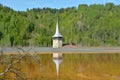 Church tower reflection in the lake of Geamana in the Apuseni Mountains, Romania Royalty Free Stock Photo