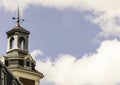 Church tower with weathervane and blue sky with clouds