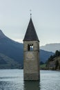 Church under water, drowned village, mountains landscape and peaks in background. Reschensee Lake Reschen Lago di Resia. Royalty Free Stock Photo