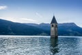 Church under water, drowned village, mountains landscape and peaks in background. Reschensee Lake Reschen Lago di Resia. Royalty Free Stock Photo