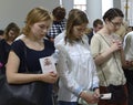 In a church. Young girls kneeling and praying during funeral service Royalty Free Stock Photo