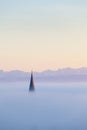 Churchtower above the fog, swiss alps in background