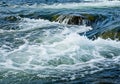Churning water with visible foam creates a dynamic scene in a river Royalty Free Stock Photo