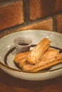 Churros Fried Spanish donuts x4 stacked and served with chocolate dip in a bowl Royalty Free Stock Photo