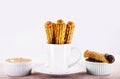 Churros in a mug, traditional fried sweet from Latin America, Brazil, Colombia, United States and Portugal, served with or without