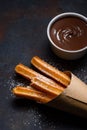 Churros in paper bag with sugar and chocolate sauce Royalty Free Stock Photo