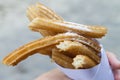 Churros sprinkled with sugar held in a paper cone