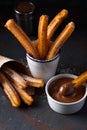 Churros with sugar and cinnamon in melted chocolate