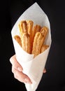 Churros traditional Spain or Mexican street fast food baked sweet dough snack in hand
